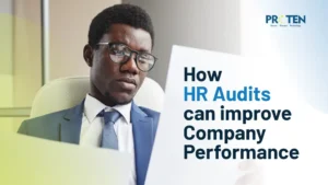 black man in suit looking over his laptop with a big text overlay titled "How HR audits can improve company performance"