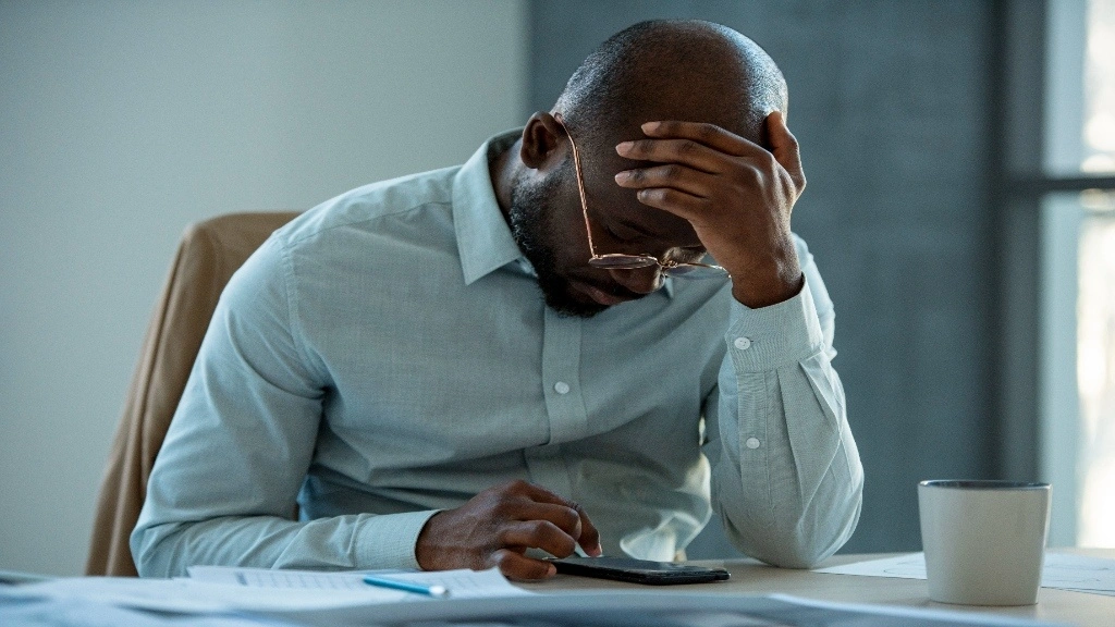 A man with his hands on his forehead.