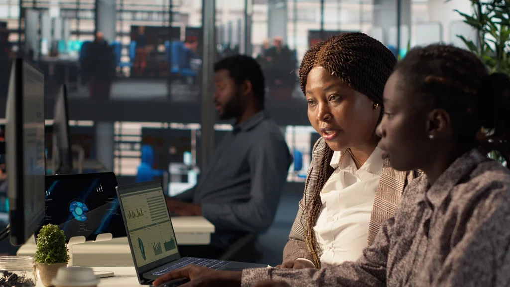 general manager reviews financial forecasts with employee desk
