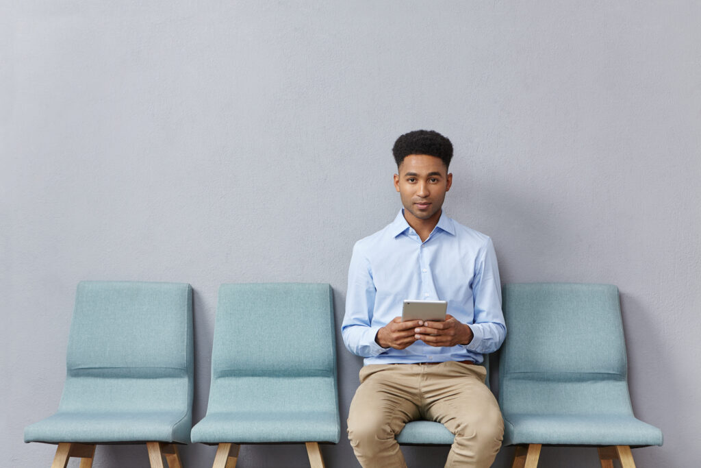 young man dressed formally sitting waiting room