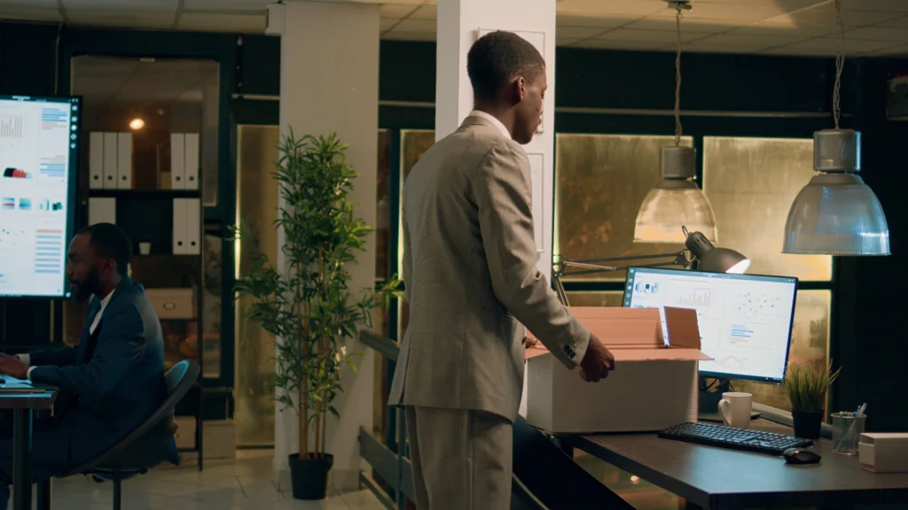 upset employee leaving modern office after deciding quit frustrated businessman packing desk belongings box last day workplace after finishing nightshift before starting new job